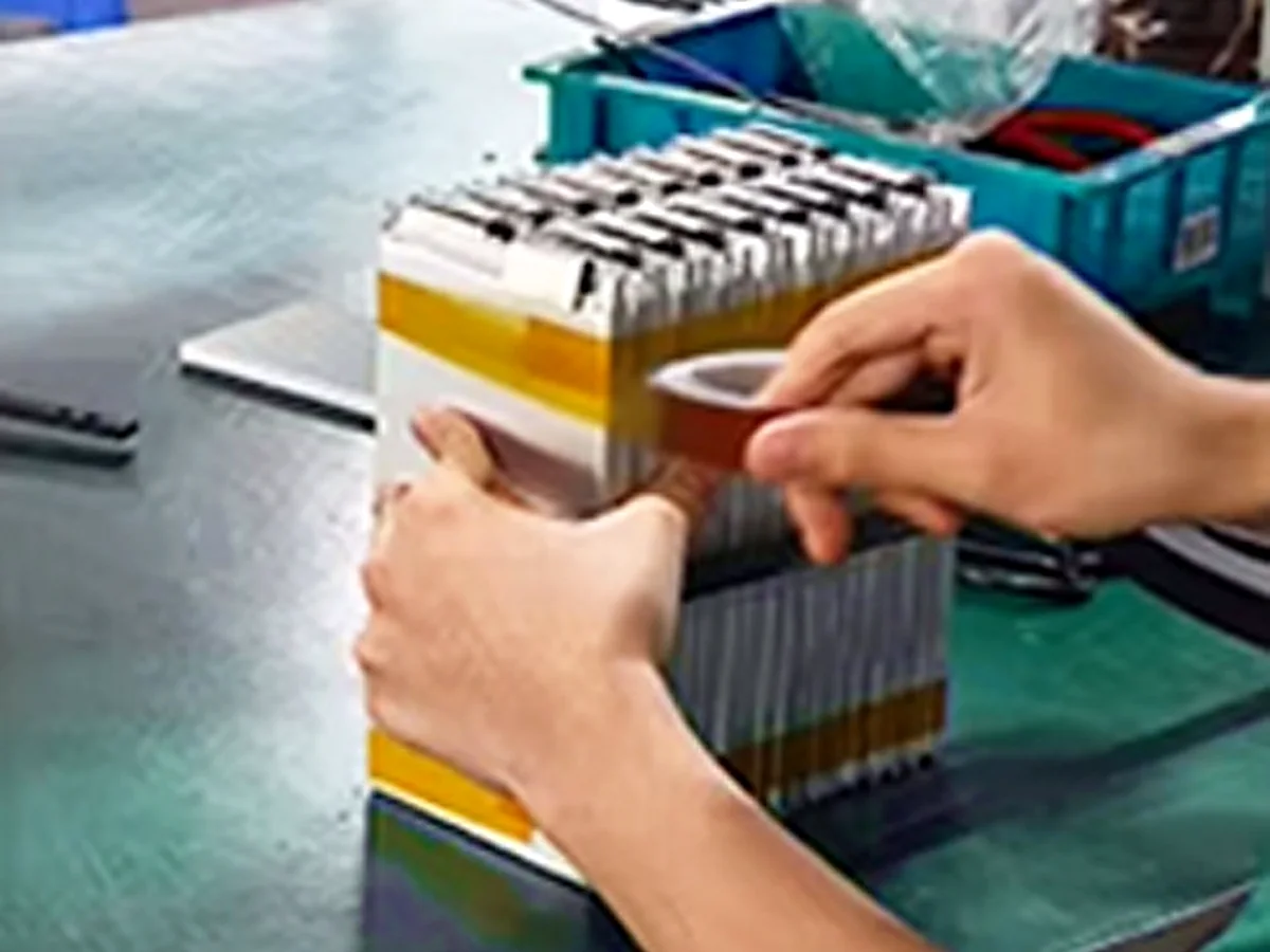 Operator assembling graded cells into a battery stack